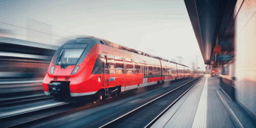 High-speed red train in motion at a modern railway station, symbolising advanced thermal component technology and engineering innovation for rail transport systems.