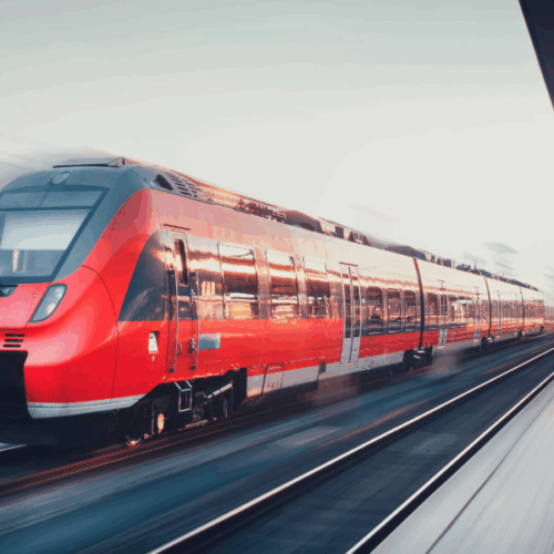High-speed red train in motion at a modern railway station, symbolising advanced thermal component technology and engineering innovation for rail transport systems.
